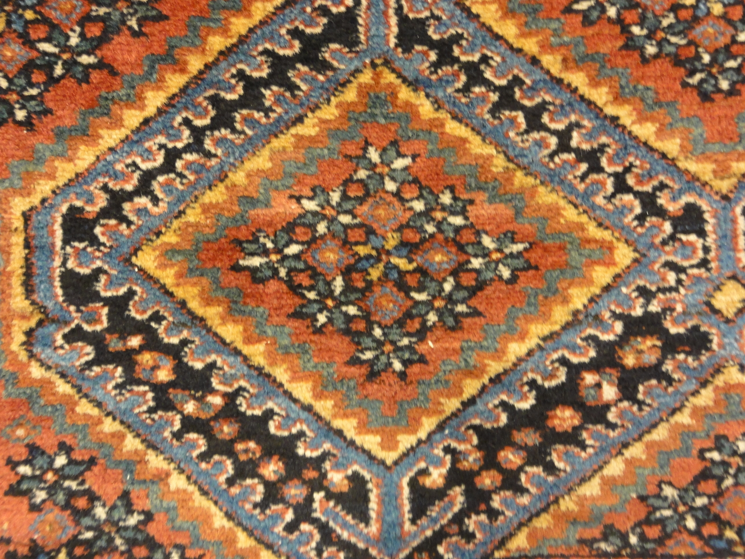 An antique Persian Afshar rug featuring a diamond pattern. A piece of genuine original woven carpet art sold by the Santa Barbara Design Center.