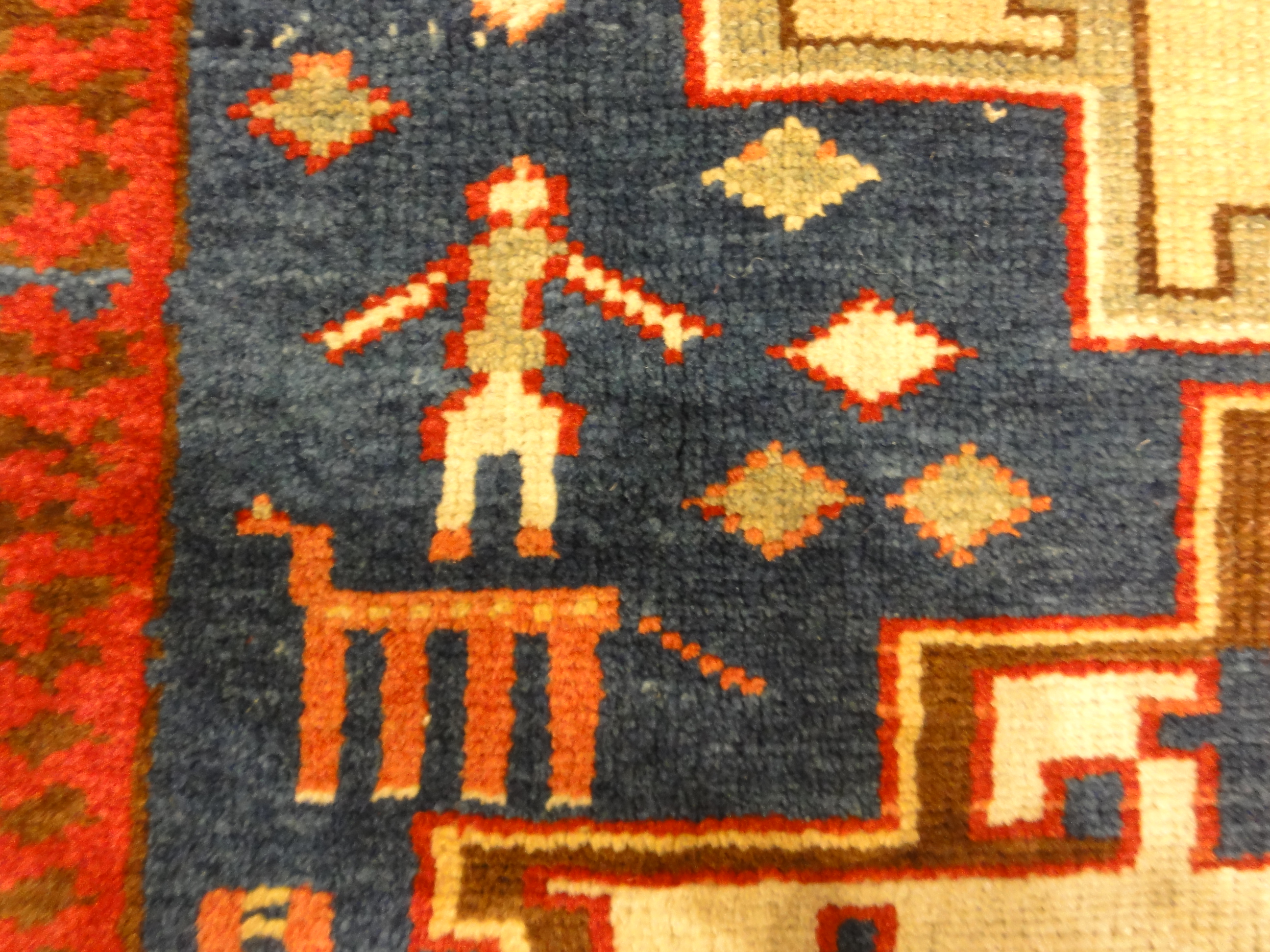 Rare Antique Leshgi Star Rug featuring Men Standing on Horses. A piece of genuine antique authentic woven carpet art sold by Santa Barbara Design Center.