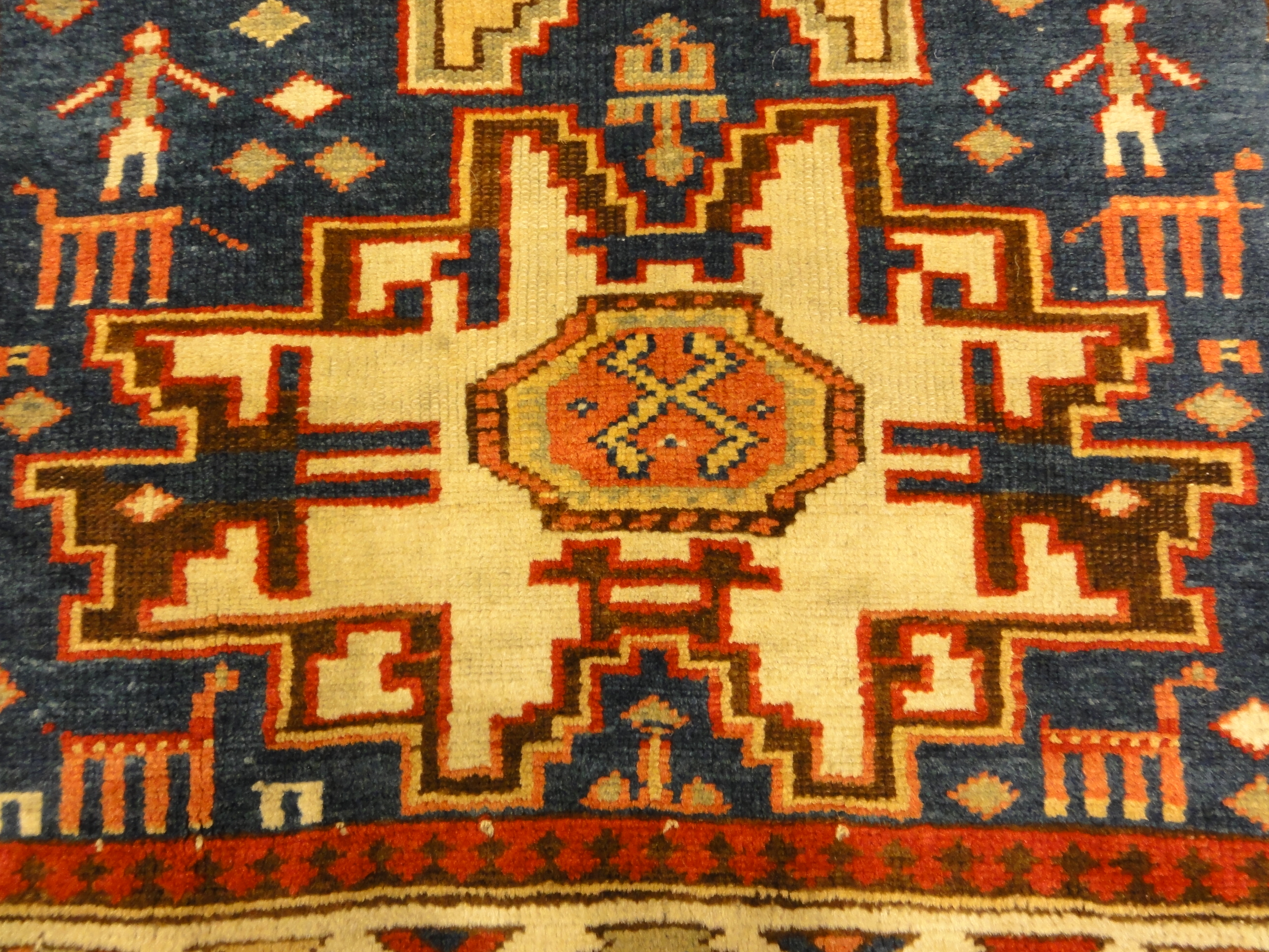Rare Antique Leshgi Star Rug featuring Men Standing on Horses. A piece of genuine antique authentic woven carpet art sold by Santa Barbara Design Center.